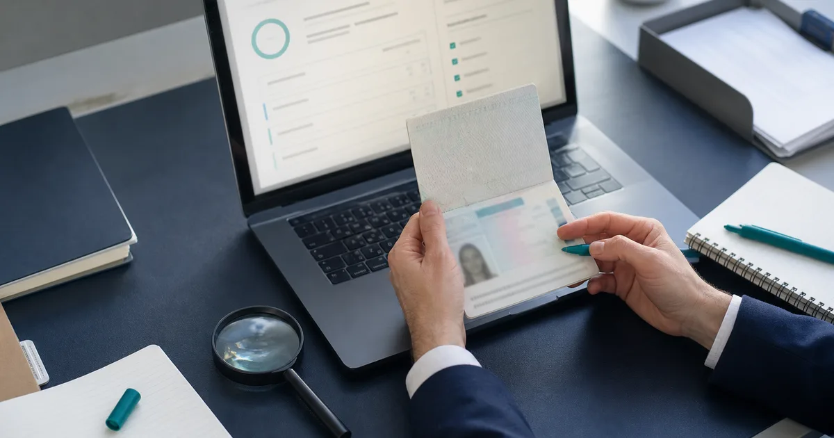 A solicitor reviewing an identity document beside a digital compliance screen
